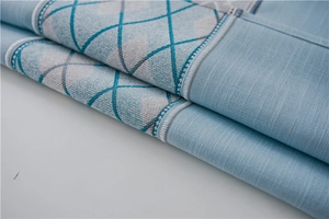 Close-up of light blue faux linen table runner with navy blue diamond geometric patterns