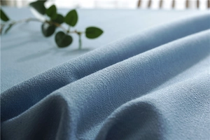 Macro shot of light blue woven fabric texture with fringe detail on a Nordic tablecloth