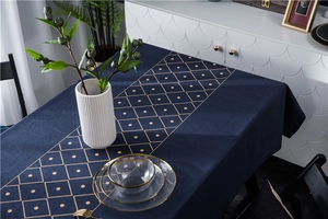 Detail of luxury navy blue velvet tablecloth featuring golden geometric diamond patterns