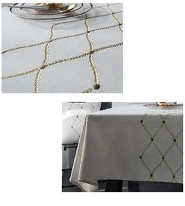 Detail of waterproof tablecloth with gold geometric embroidery and premium linen texture