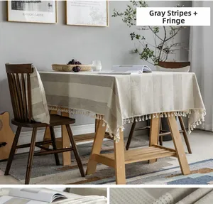 Close-up of Nordic style grey striped tablecloth with white decorative fringe tassels