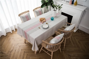 Detail of waterproof checkered table runner with fringes and matching cushion covers