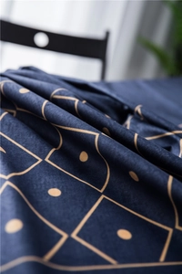 Detail of luxury navy velvet tablecloth featuring golden geometric lines and soft texture