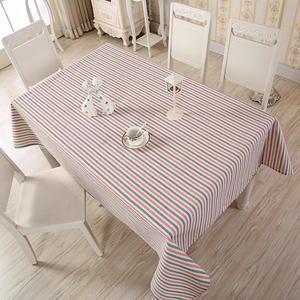 Detailed close-up of striped cotton tablecloth draped over a rectangular dining table