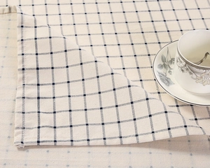 Detailansicht der cremefarbenen Tischdecke aus Baumwollleinen mit dunkelblauen Karos
