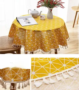 Close-up of yellow geometric print tablecloth with cotton tassels and linen texture