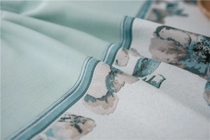 Close-up of mint green faux linen table runner with floral jacquard texture