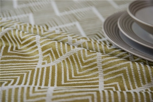 Close-up of olive green and beige jacquard fabric with vintage geometric zigzag pattern