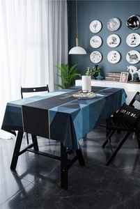 Detail of geometric velvet tablecloth with blue patterns and gold text for modern decor