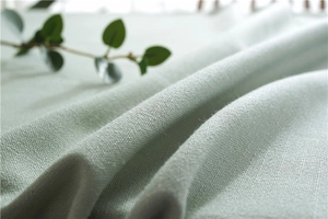 Detailed macro view of mint green linen fabric texture with heavy weave for tablecloths