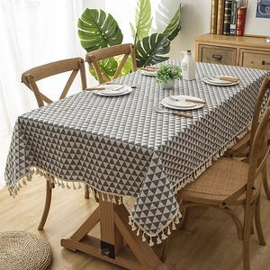 Modern grey and white geometric triangle tablecloth with tassel fringe on wood table