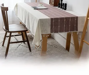 Close-up of violet and cream checkered linen tablecloth with white decorative tassels