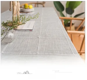Macro shot of grey linen coffee tablecloth with white cross-stitch grid embroidery texture