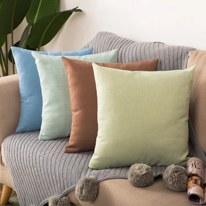 Close-up of linen texture cushions in blue, green and tan on a neutral sofa