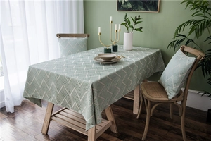 Detail of green and white geometric striped tablecloth on wooden table in Nordic style