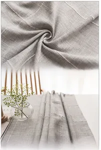 Macro shot of grey linen table runner showing intricate embroidery and stitching details