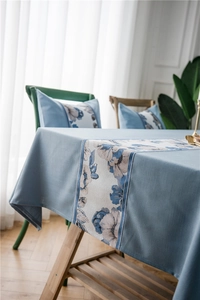 Macro detail of waterproof blue linen-textured table runner with floral jacquard pattern