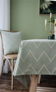 Detail of sage green and white V-pattern jacquard tablecloth with matching cushion cover