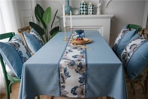 Detail of waterproof linen-style table runner with blue floral patterns in a dining setting