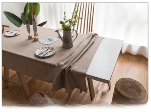Detail of light brown linen-cotton tablecloth with white grid pattern and natural texture