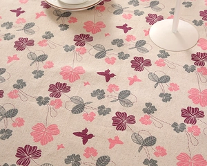 Close-up of cotton linen tablecloth showing purple floral patterns and woven texture