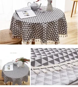 Detailed close-up of grey and white geometric triangle pattern on round tassel tablecloth
