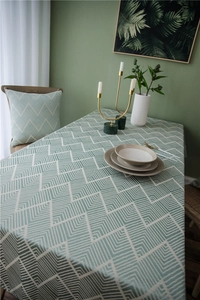 Close-up of waterproof sage green jacquard tablecloth with white herringbone pattern texture