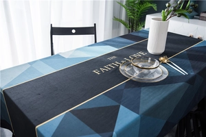 Detail of velvet tablecloth with blue geometric patterns and gold lettering