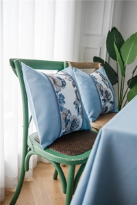Close-up of blue floral faux linen pillow cases on a vintage wooden chair setting