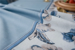 Macro detail of waterproof blue floral jacquard stitching on linen texture tablecloth