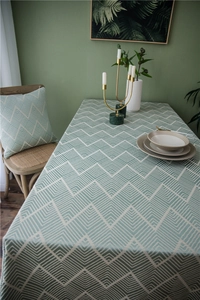 Detail of waterproof jacquard tablecloth with light green wavy pattern in Nordic style