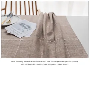 Detail of embroidered faux linen tablecloth with neat stitching and white plaid pattern
