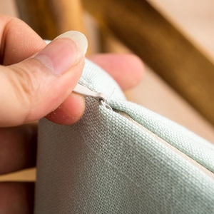 Detail of invisible zipper on mint green textured cotton linen tablecloth fabric