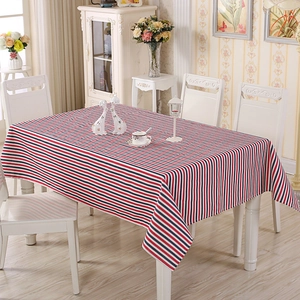 Detail of red, white and blue striped tablecloth on a wooden table in home setting