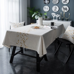Detailed close-up of beige waterproof tablecloth with golden feather embroidery patterns