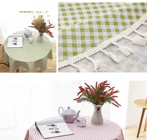 Detail of green and pink plaid tablecloth with white tassels and woven linen texture