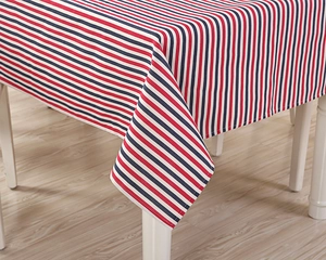Detailed close-up of striped poly-cotton tablecloth on a white wooden dining table
