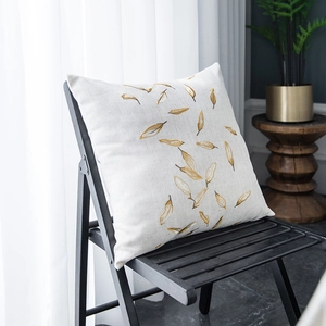 Detail of embroidered pillowcase with yellow leaf patterns on beige linen fabric