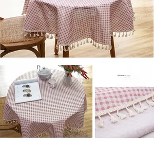 Detailed close-up of round tablecloth featuring red plaid pattern and fringe tassel edges