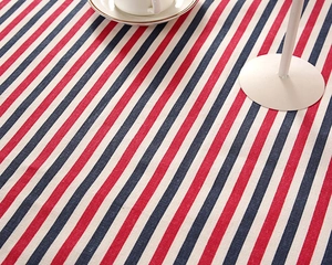 Detail of red and navy blue striped cotton linen tablecloth texture with a coffee cup