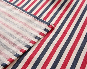 Detailed macro view of red, navy, and white striped cotton-polyester fabric stitching