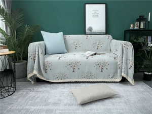 Detail of chenille sofa cover showing elegant lace trim and gray-blue tree pattern