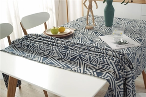 Close-up of modern navy and beige geometric jacquard tablecloth with textured fringes