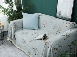 Close-up of chenille sofa cover featuring tree patterns and delicate lace edge