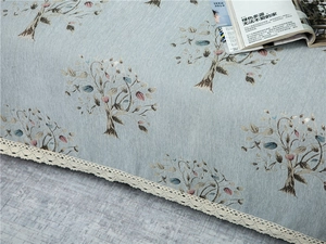 Close-up of light blue chenille sofa cover with tree pattern and white lace edge