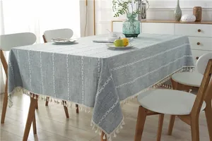 Close-up of Nordic style light blue linen tablecloth with white cross embroidery and tassels