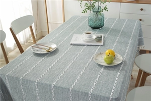 Detail of blue textured tablecloth with white chain embroidery and tassel trim