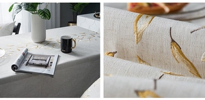 Detail of grey cotton linen tablecloth with elegant gold feather embroidery texture
