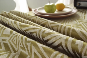 Close-up of olive green geometric jacquard tablecloth fabric with thick woven texture