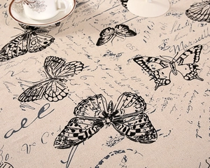 Detail of vintage linen tablecloth featuring black butterfly print and script typography